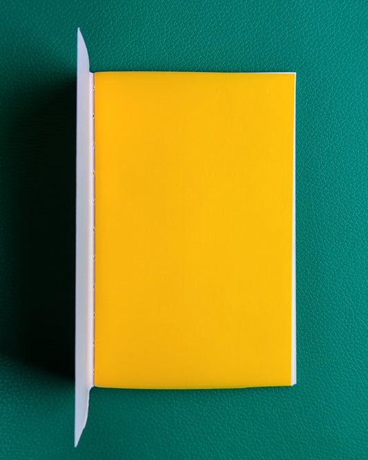 Travellers style notebook open to show bright yellow inner page