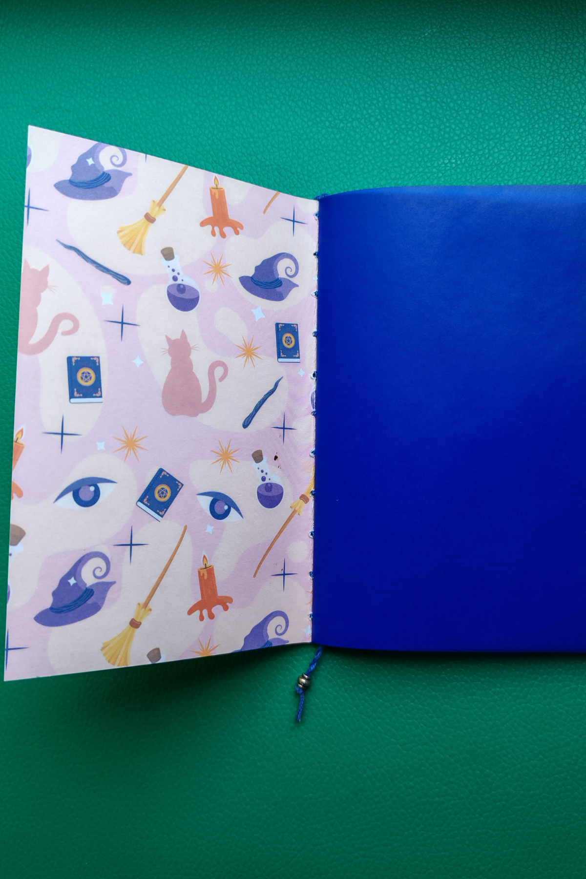 Open notebook showing patterned inner cover and dark blue vellum first page