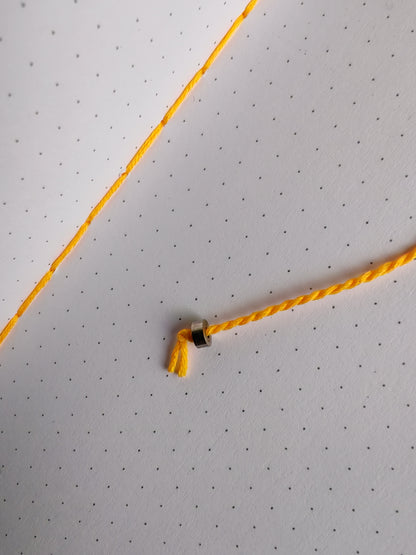 Yellow thread book mark with metal bead