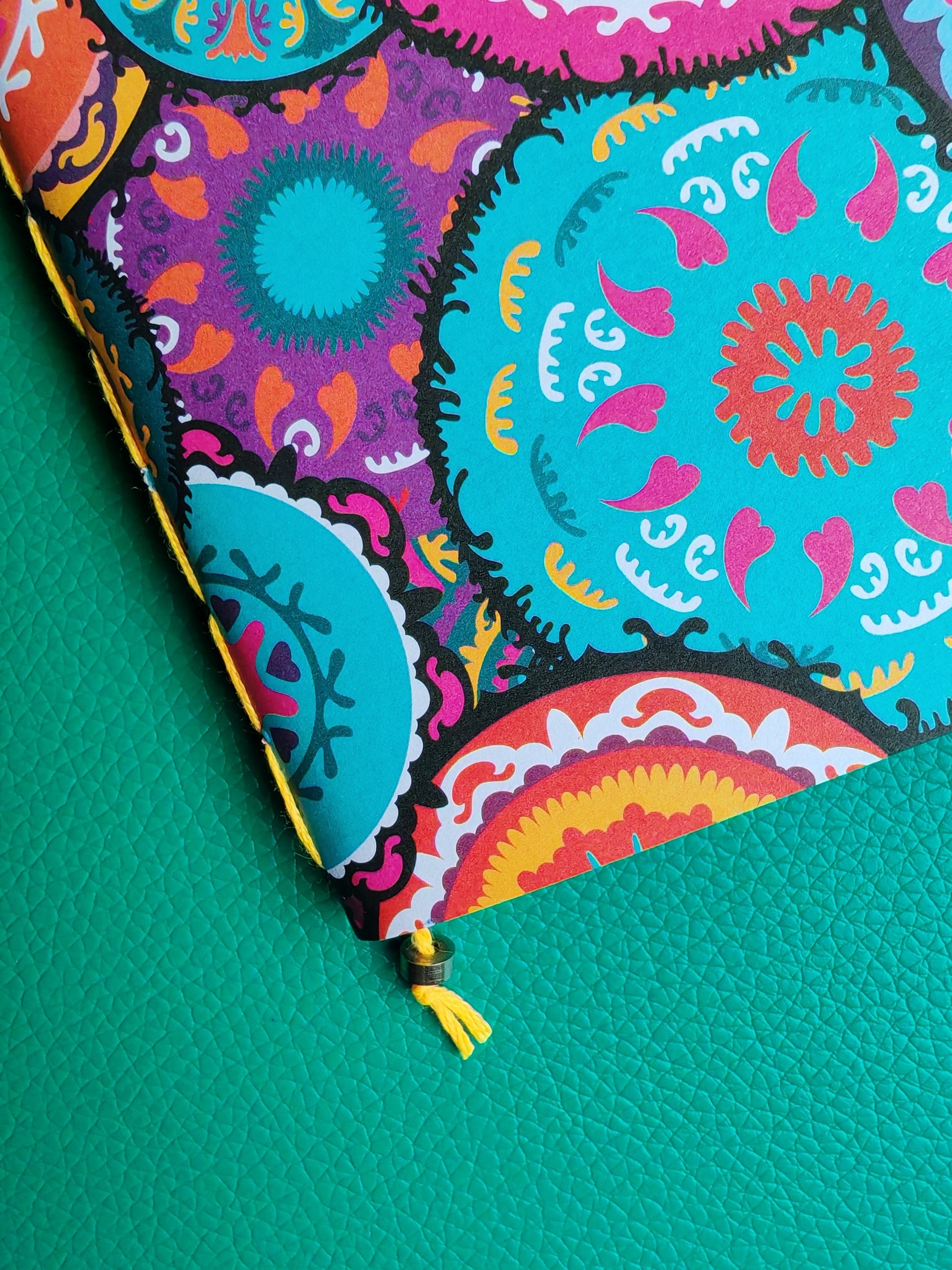 Colourful notebook close up showing saddle stitch binding in yellow