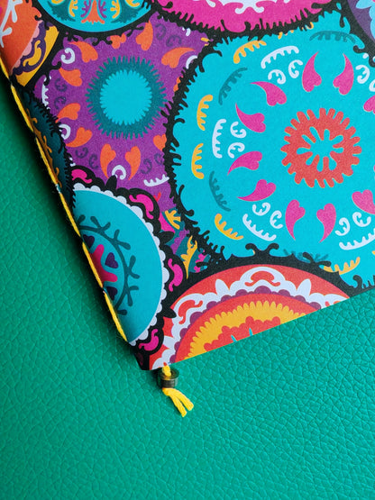 Colourful notebook close up showing saddle stitch binding in yellow