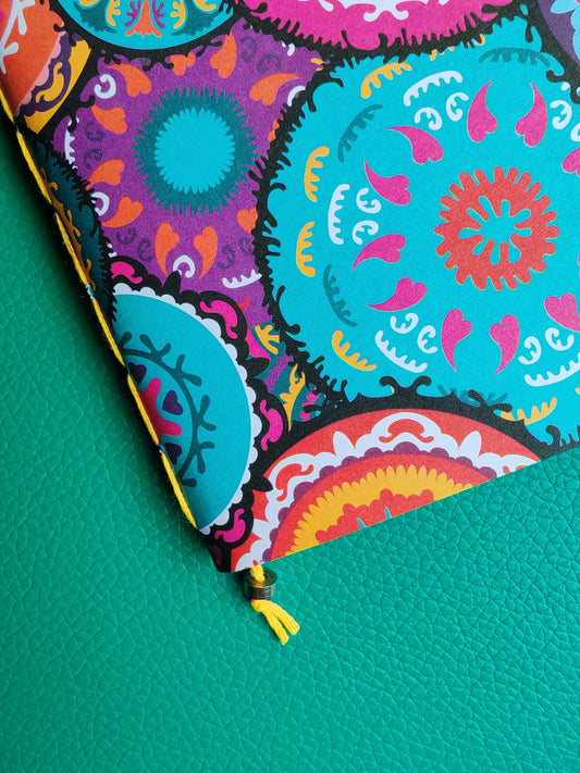 Colourful notebook close up showing saddle stitch binding in yellow