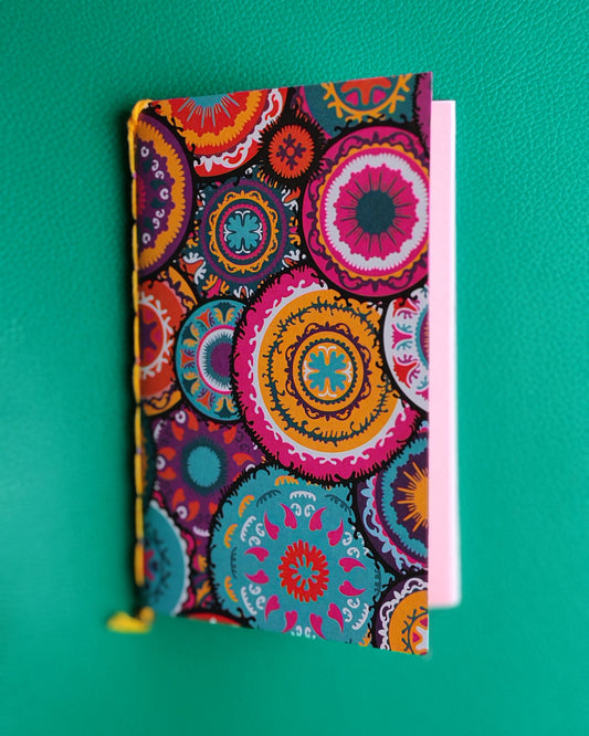 Colorful  notebook with overlapping mandala circles on a green background