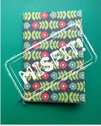 Notebook with floral pattern and 'MISPIT' text on a green background