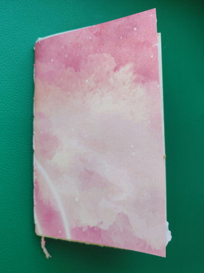 Pink notebook with cloud pattern on a green background