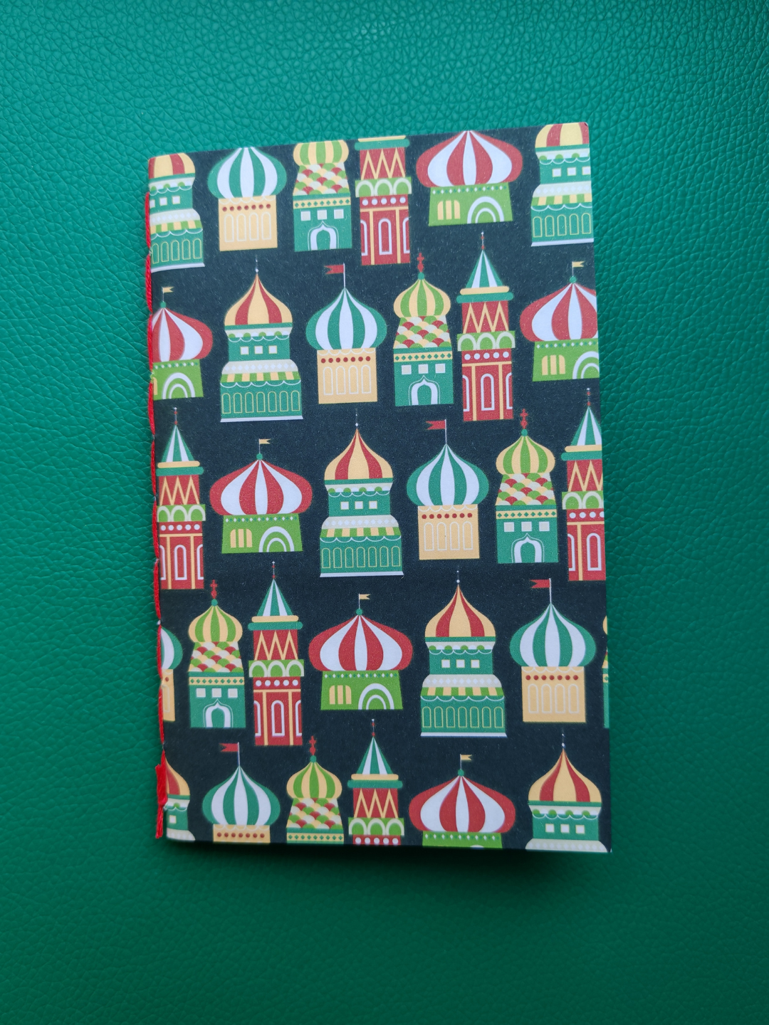 Notebook with colorful architectural design on a green background