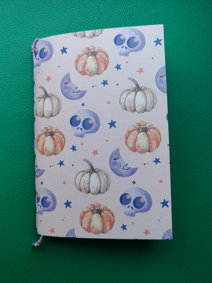 Notebook with pumpkin and skull pattern on a green background