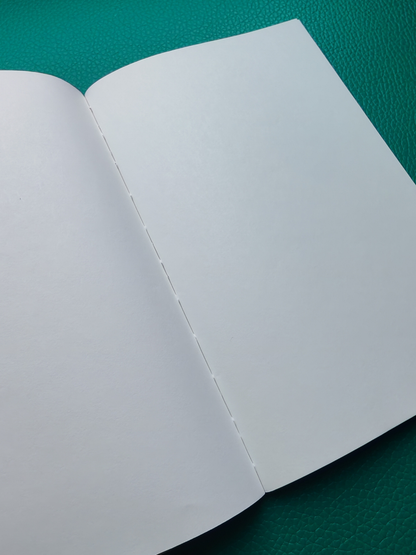 Open book with blank pages on a green surface