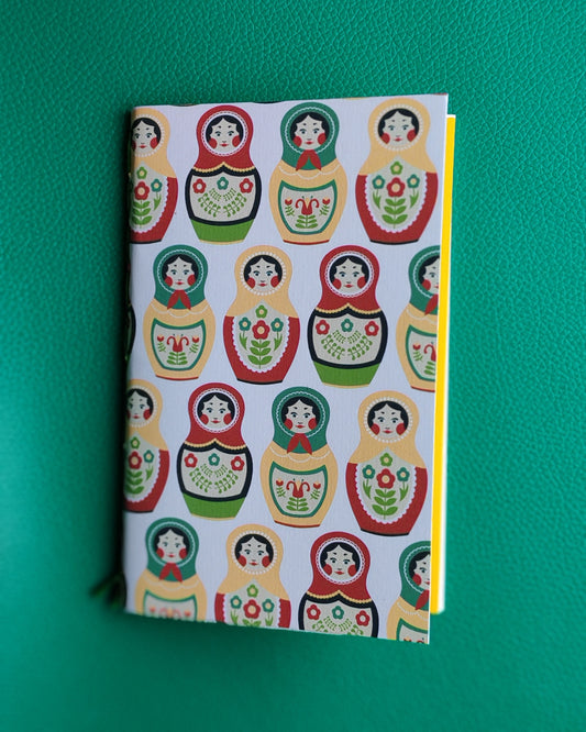 Notebook with Russian nesting doll design on a green background