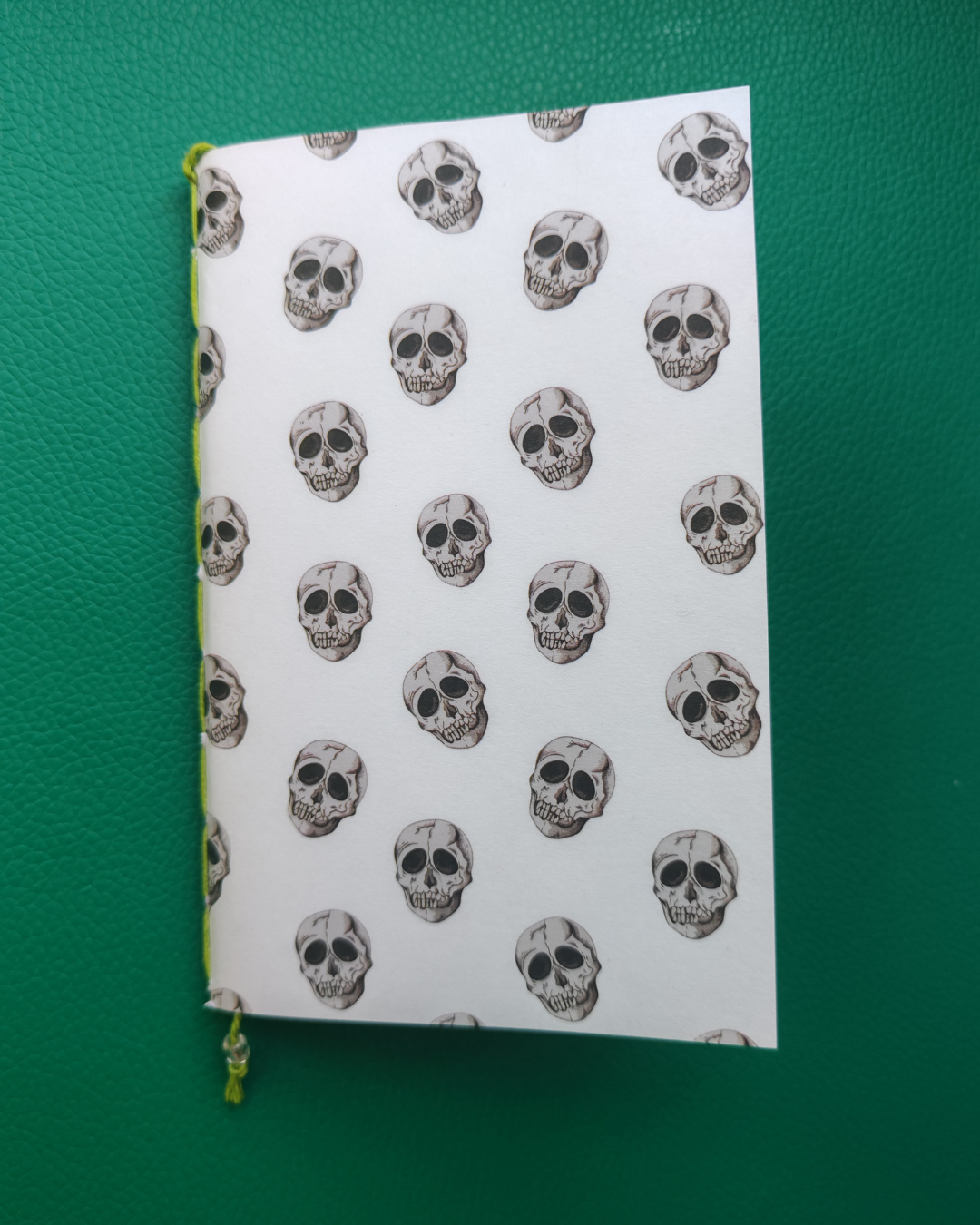 Notebook with skull pattern on a green surface