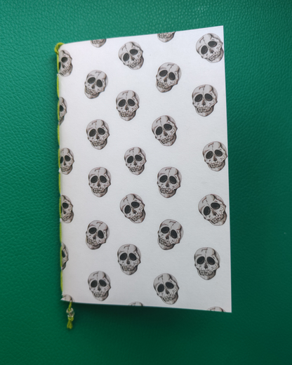 Notebook with skull pattern on a green surface
