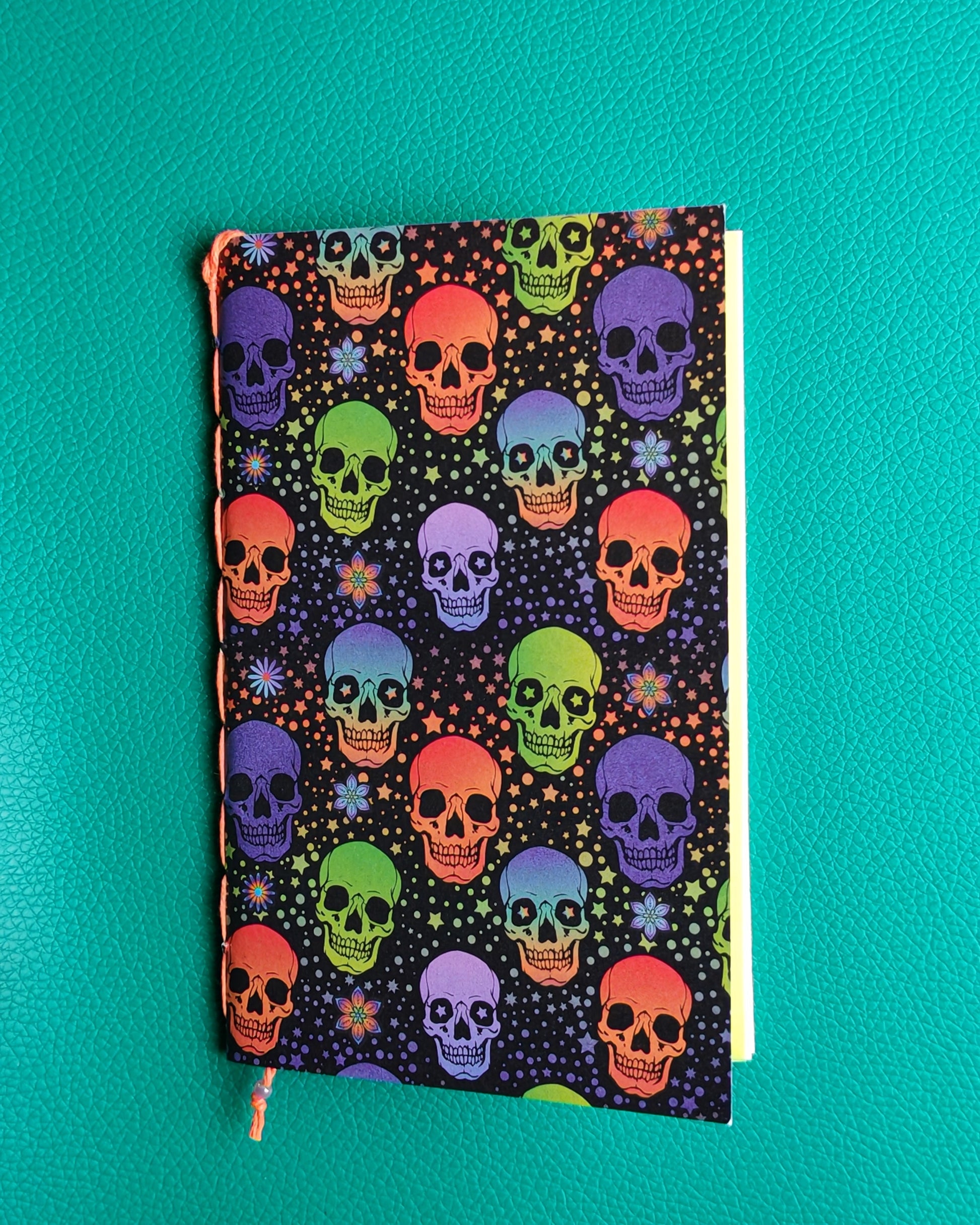 travelers notebook insert with colorful skull pattern on a teal background