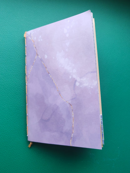 Purple notebook with gold accents on a green background