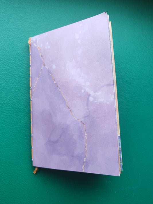 Purple notebook with gold accents on a green background