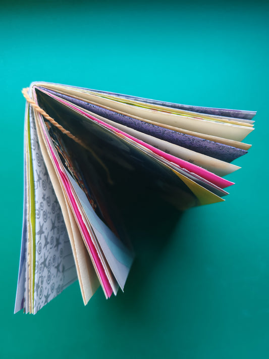 Top view off open junk journal with colorful mixed media pages 