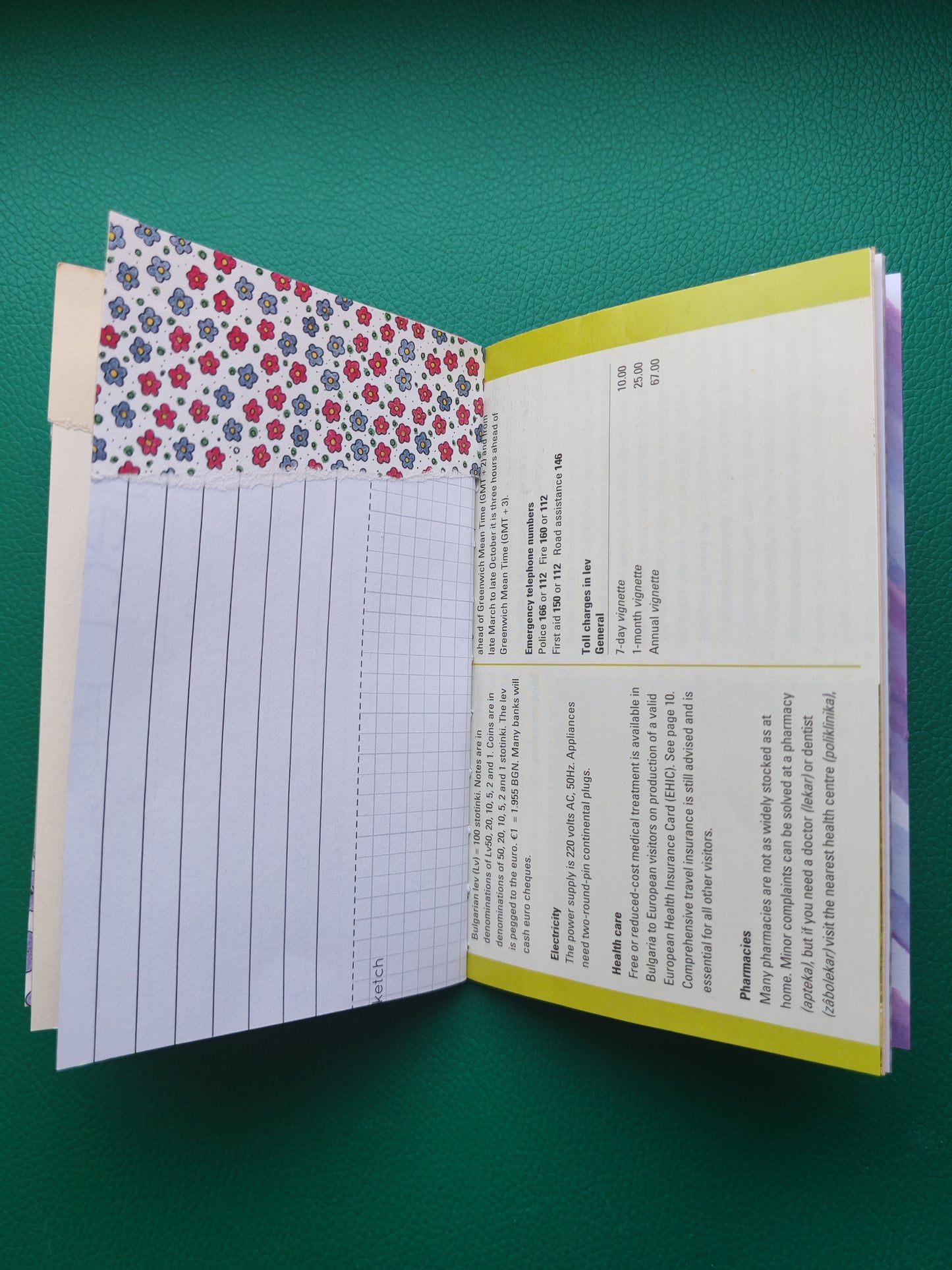 Open notebook with floral and lined pages on a green background