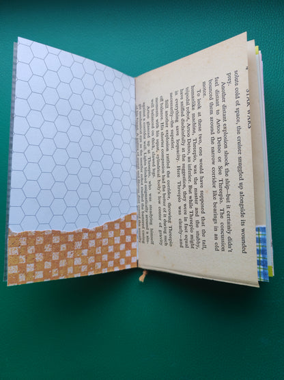 Open notebook with decorative page on a green background