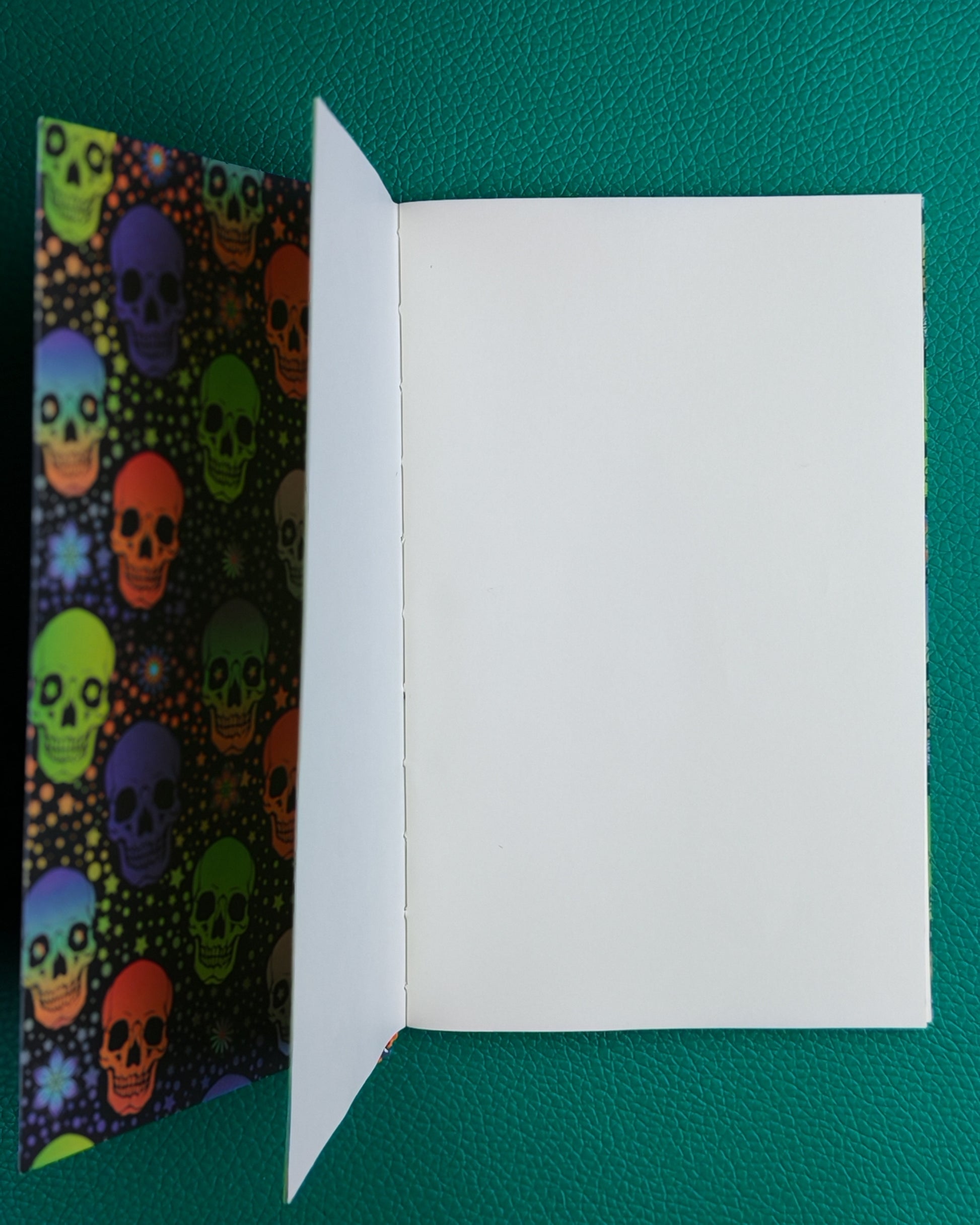 Colorful skull patterned notebook open to show plain tomoe river paper pages