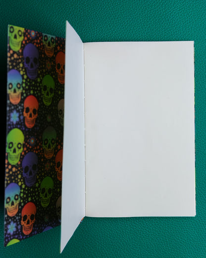 Colorful skull patterned notebook open to show plain tomoe river paper pages