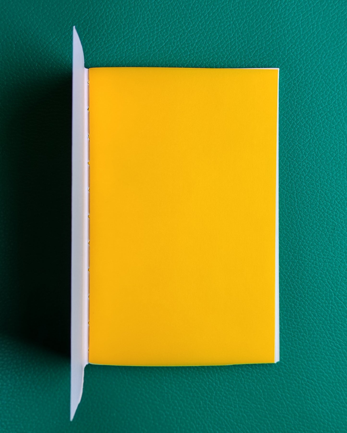 Travellers style notebook open to show bright yellow inner page