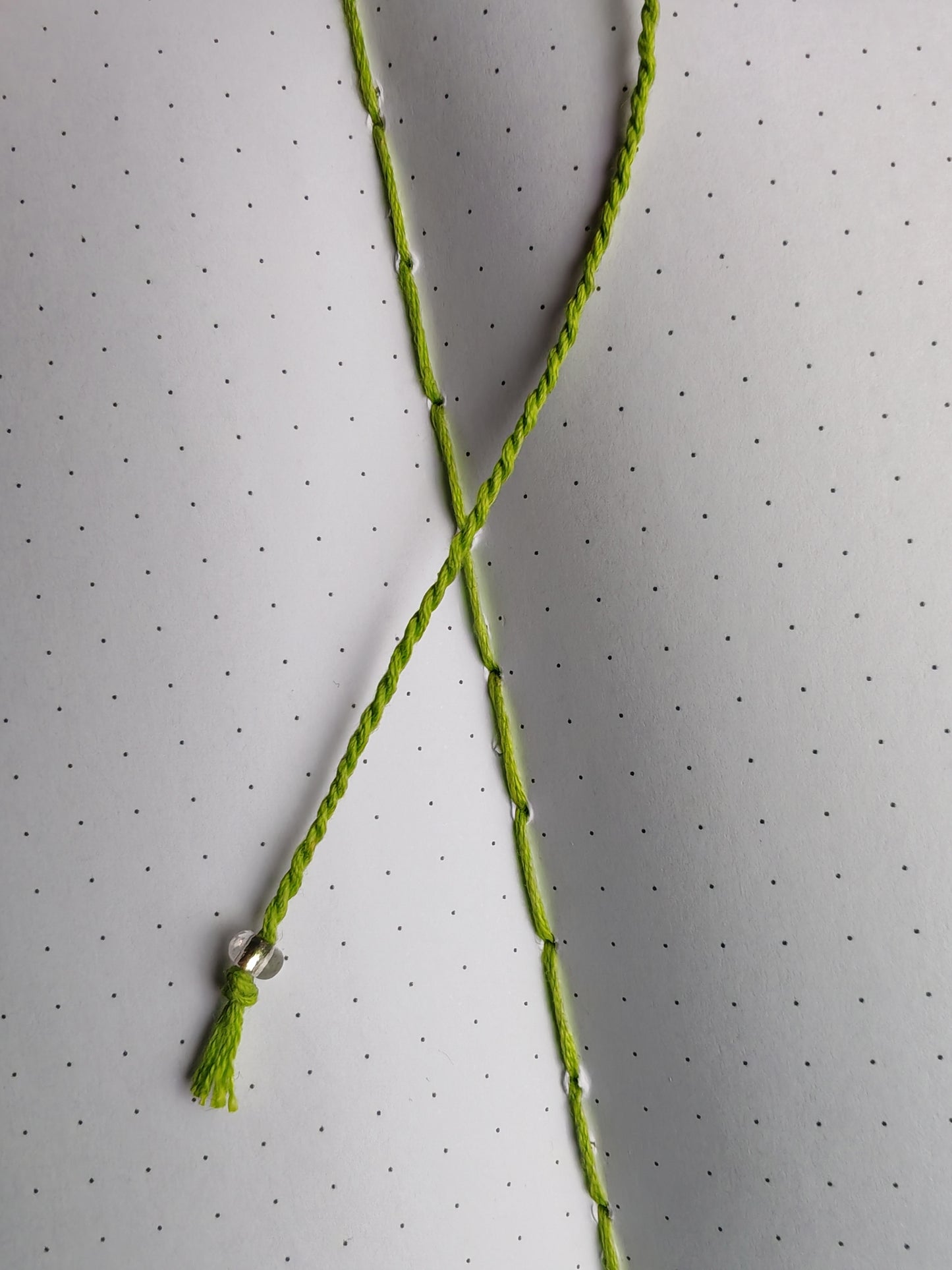 green thread bookmark with a clear glass bead