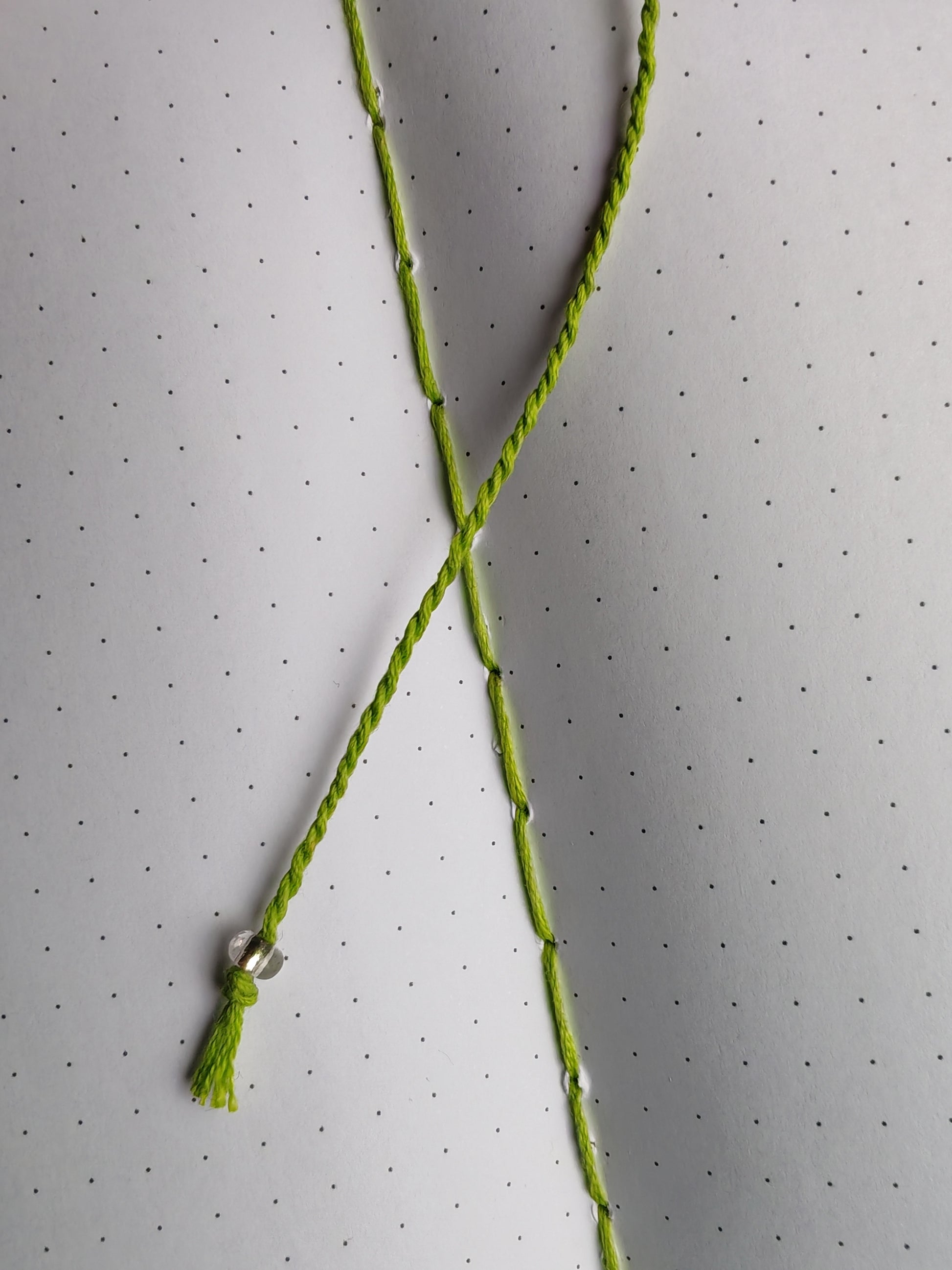 green thread bookmark with a clear glass bead