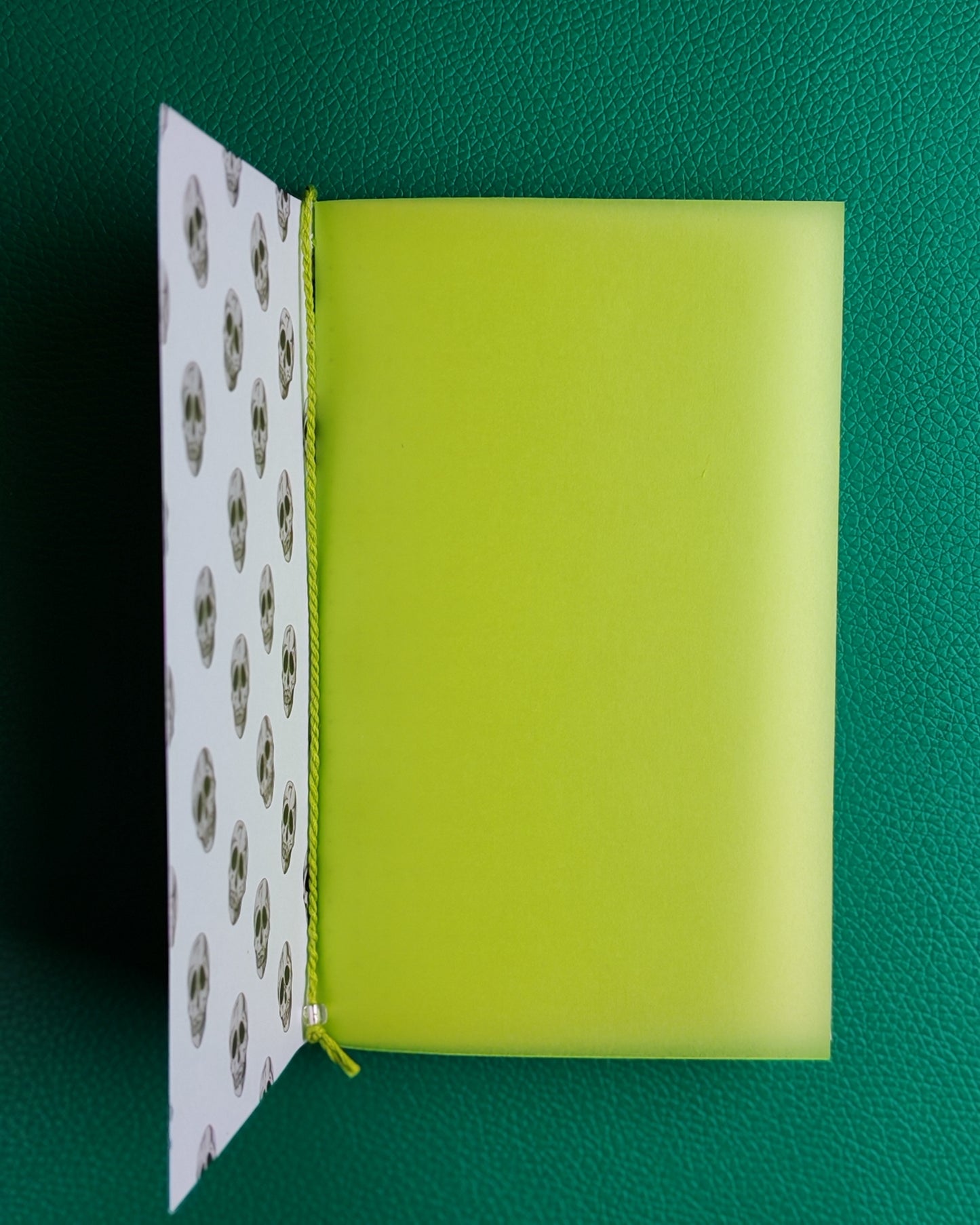 Open notebook displaying lime green inner flyleaf as first page