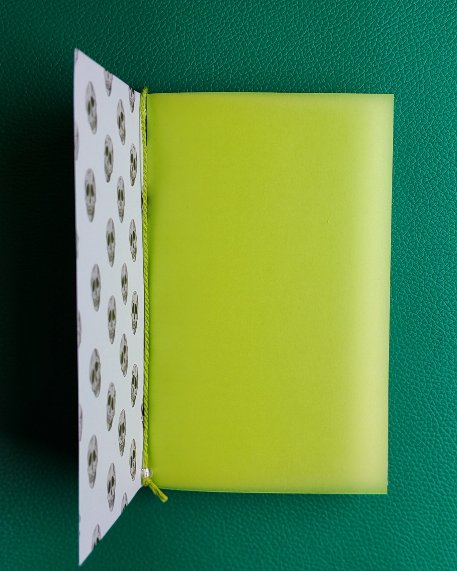 Open notebook displaying lime green inner flyleaf as first page