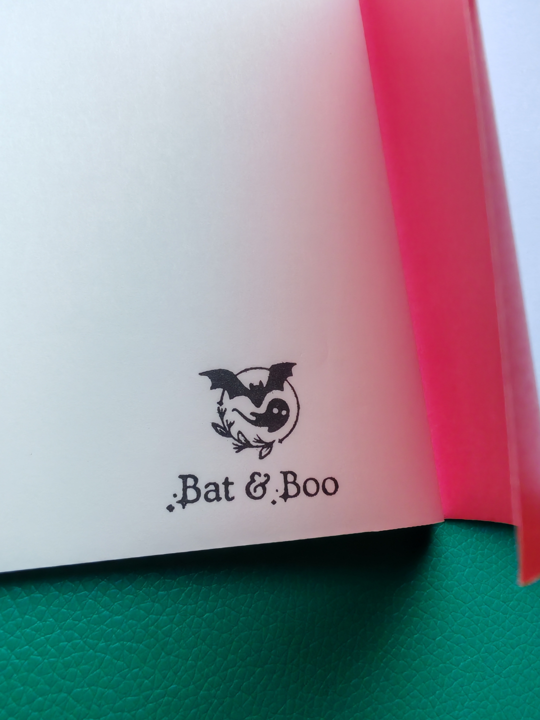 Open book with 'Bat & Boo' logo on a green surface