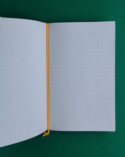 Open notebook with yellow binding on a green background